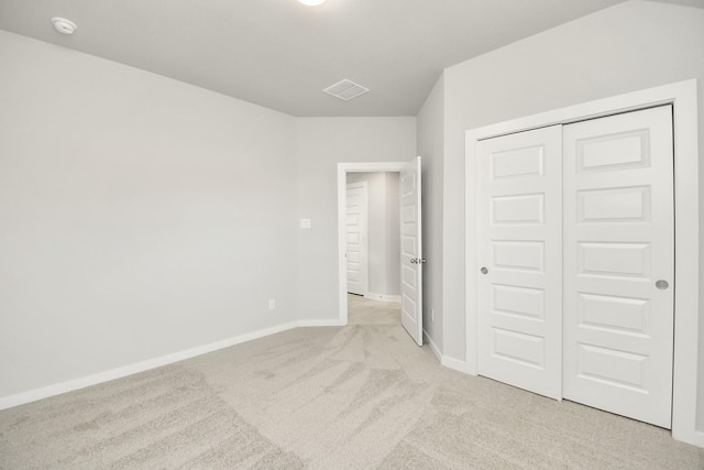 unfurnished bedroom featuring light colored carpet and a closet