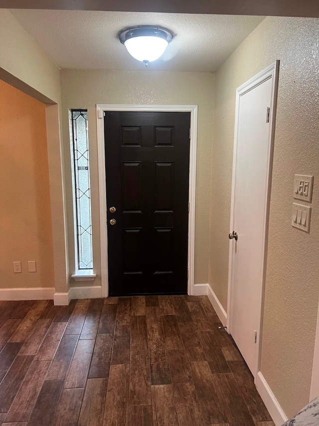 entrance foyer with a textured ceiling and dark wood-type flooring