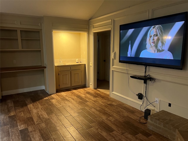 home theater room with sink, lofted ceiling, and hardwood / wood-style flooring