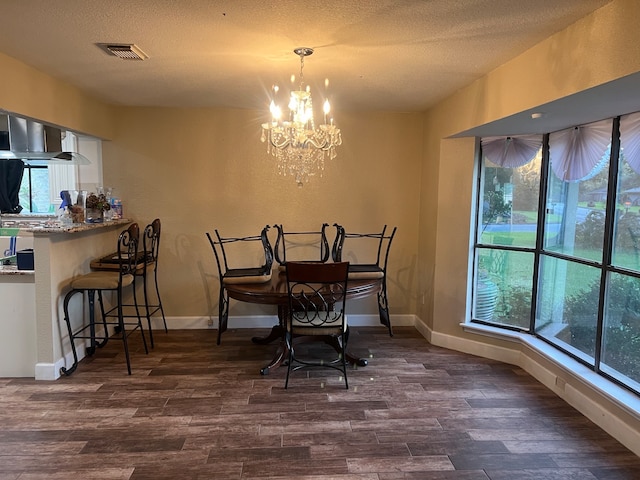 dining room featuring a textured ceiling, hardwood / wood-style floors, and a chandelier