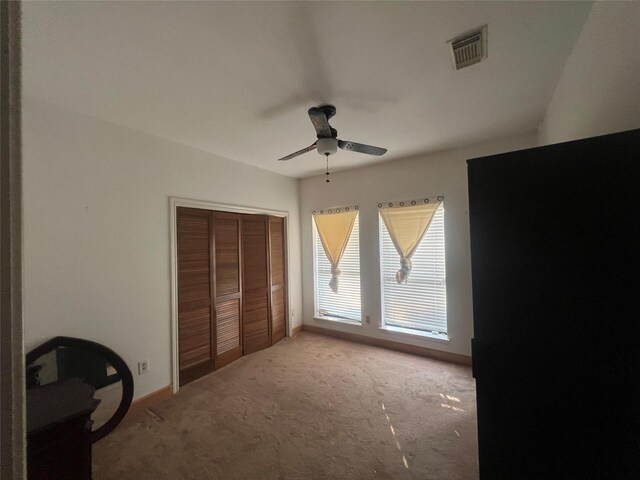 unfurnished bedroom with a closet, ceiling fan, and carpet