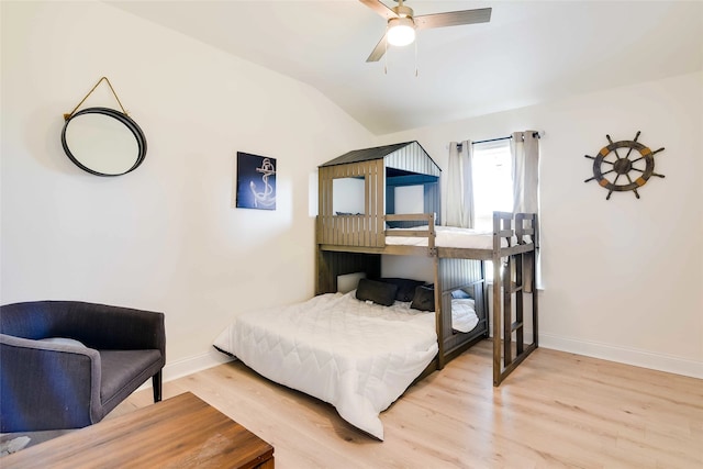 bedroom featuring ceiling fan, light hardwood / wood-style floors, and lofted ceiling