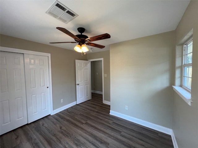 unfurnished bedroom featuring dark hardwood / wood-style flooring, a closet, and ceiling fan