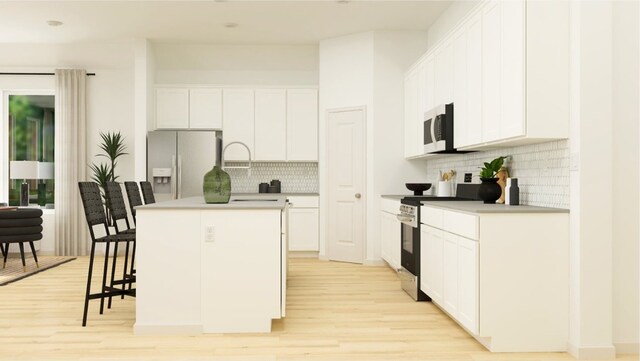 kitchen featuring white cabinets, light hardwood / wood-style floors, a kitchen island with sink, and appliances with stainless steel finishes