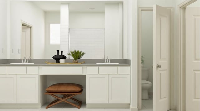 bathroom with toilet, vanity, and tile patterned floors