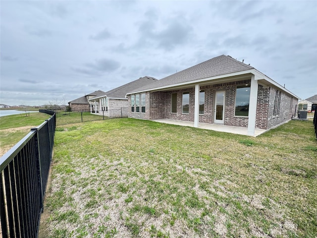 back of house featuring a lawn and a patio area