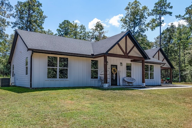 view of front of home featuring cooling unit and a front yard