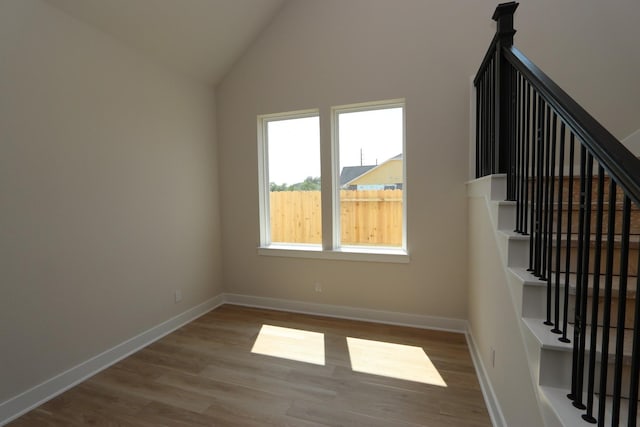 interior space with hardwood / wood-style flooring and lofted ceiling