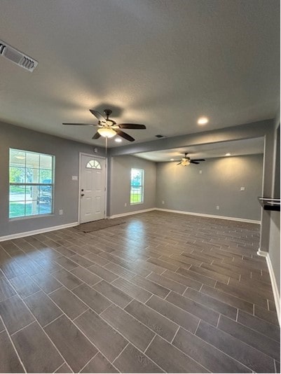 empty room with ceiling fan and dark hardwood / wood-style floors