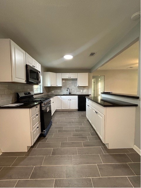 kitchen with backsplash, white cabinetry, gas stove, sink, and black dishwasher