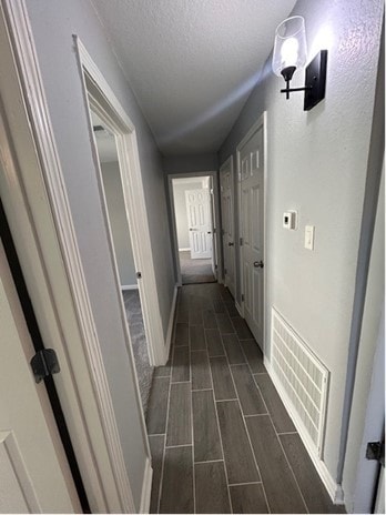 hall featuring a textured ceiling