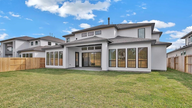 back of house featuring a lawn and a patio area