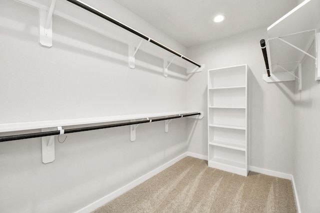 walk in closet featuring light colored carpet