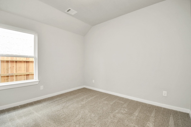 carpeted spare room featuring lofted ceiling