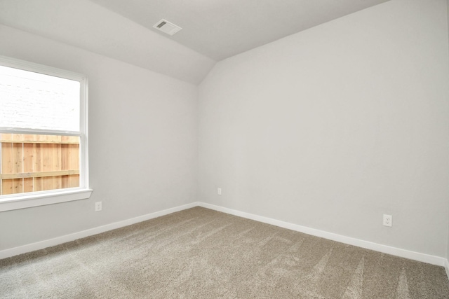 unfurnished room featuring lofted ceiling, visible vents, carpet floors, and baseboards