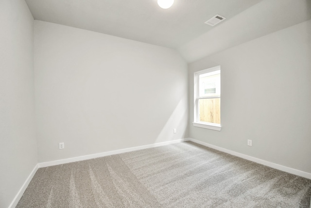 unfurnished room featuring carpet and lofted ceiling