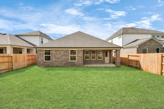 back of house with a lawn, roof with shingles, a patio, and a fenced backyard