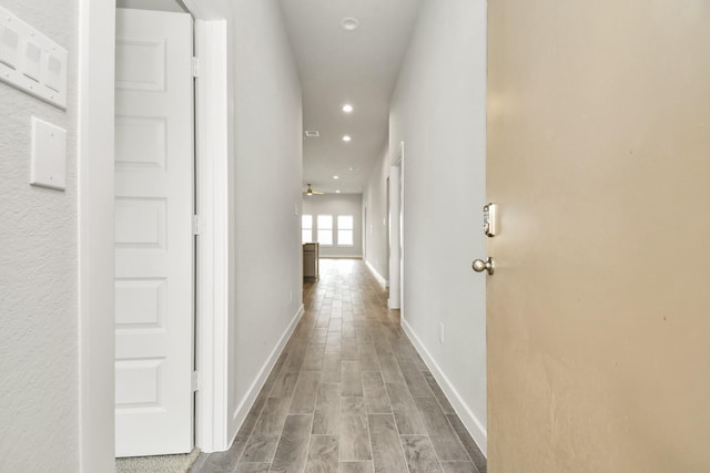 hallway with recessed lighting, wood finished floors, and baseboards