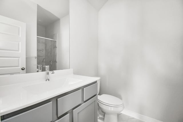 bathroom with a shower stall, baseboards, toilet, vanity, and marble finish floor