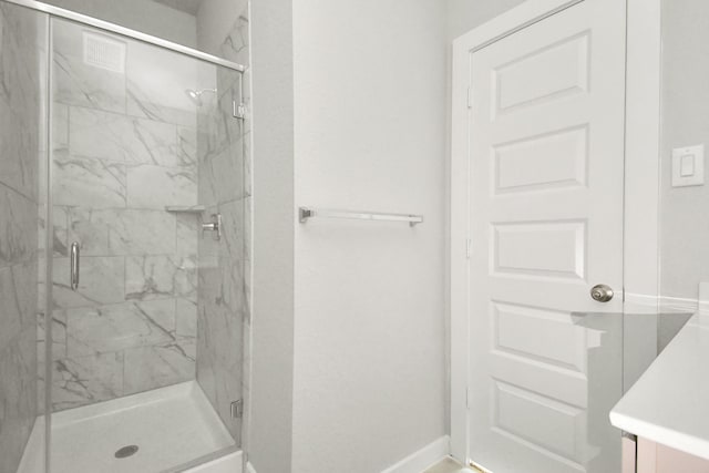 full bathroom featuring a marble finish shower, vanity, and baseboards