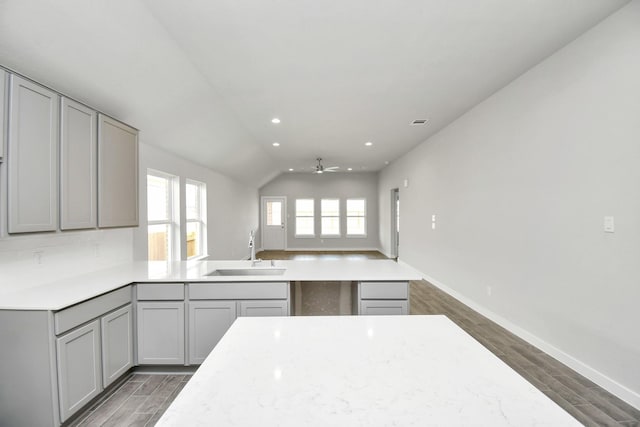 kitchen with dark wood finished floors, ceiling fan, gray cabinets, and a sink