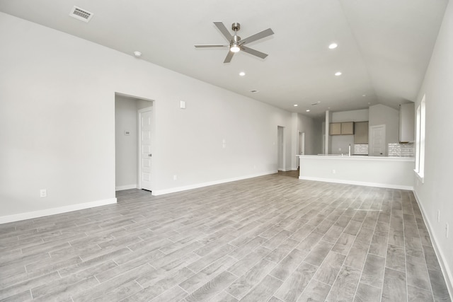 unfurnished living room featuring ceiling fan, light hardwood / wood-style flooring, and lofted ceiling