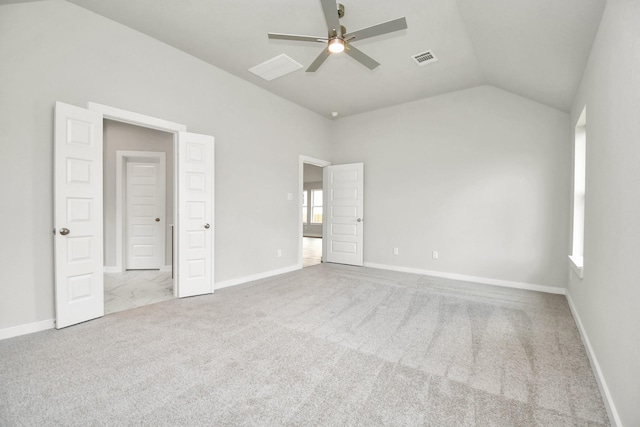 unfurnished bedroom featuring baseboards, visible vents, carpet floors, and vaulted ceiling