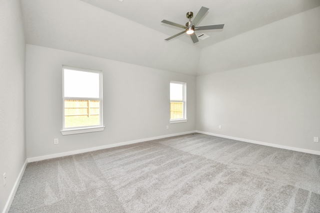 carpeted empty room featuring lofted ceiling, ceiling fan, and plenty of natural light