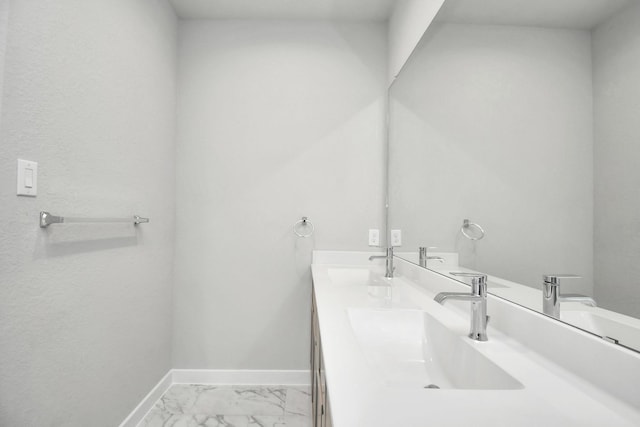 bathroom featuring double vanity, baseboards, marble finish floor, and a sink