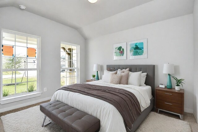 bedroom with baseboards, multiple windows, light colored carpet, and vaulted ceiling