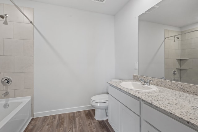 full bathroom with tiled shower / bath, toilet, vanity, and hardwood / wood-style flooring