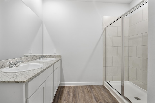 bathroom with hardwood / wood-style flooring, vanity, and walk in shower