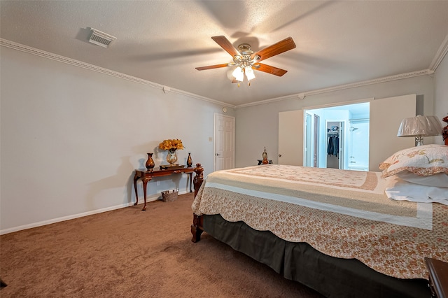 carpeted bedroom with ceiling fan, crown molding, a textured ceiling, and a walk in closet