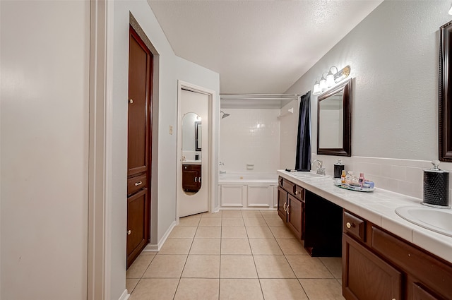 bathroom featuring tile patterned floors, plus walk in shower, and vanity