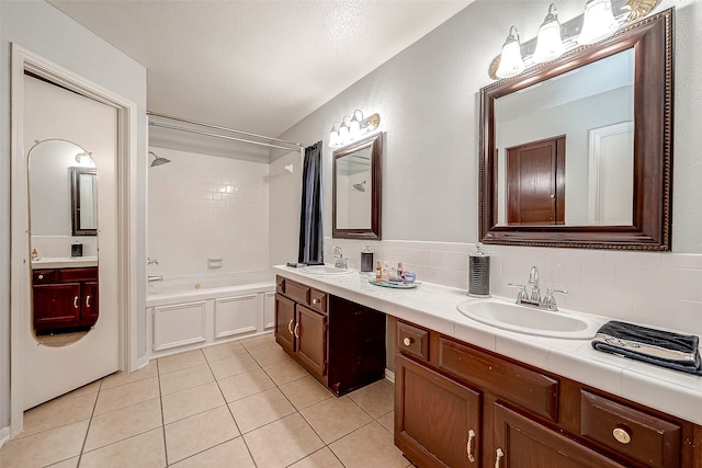 bathroom with tiled shower / bath combo, tile patterned floors, backsplash, and vanity