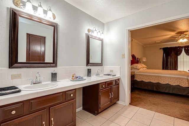 bathroom featuring ceiling fan, backsplash, tile patterned flooring, vanity, and a textured ceiling