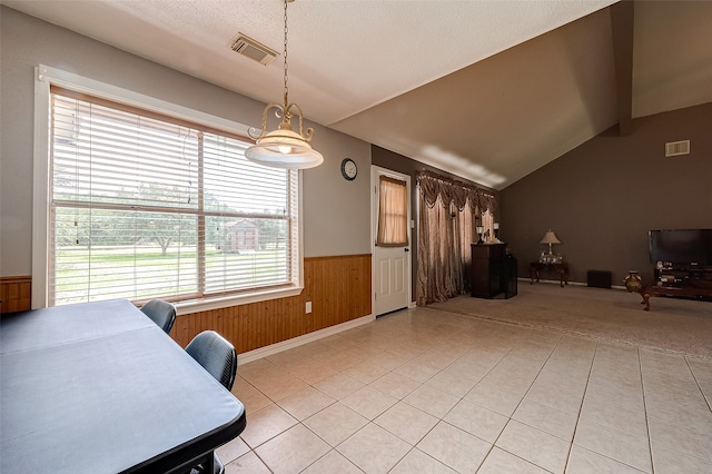 tiled dining room featuring vaulted ceiling