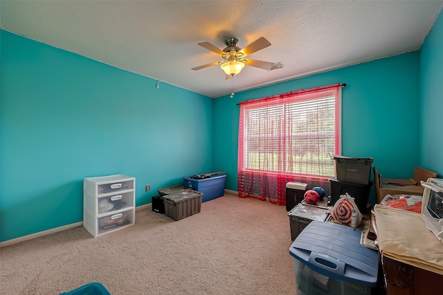 playroom featuring ceiling fan, a textured ceiling, and light carpet