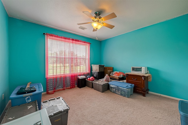 interior space with ceiling fan and carpet