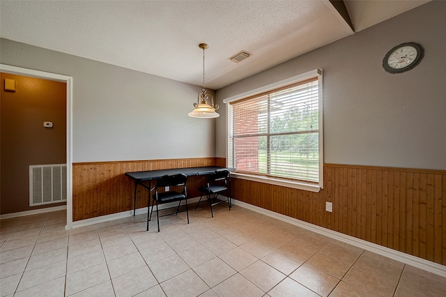 dining area featuring light tile patterned floors and a textured ceiling