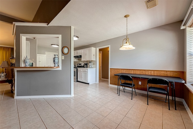 kitchen with white cabinetry, stainless steel stove, and light tile patterned floors