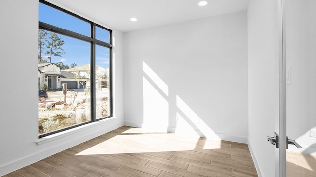 empty room featuring expansive windows and light wood-type flooring