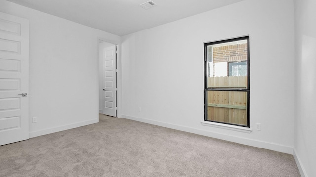 spare room featuring light colored carpet