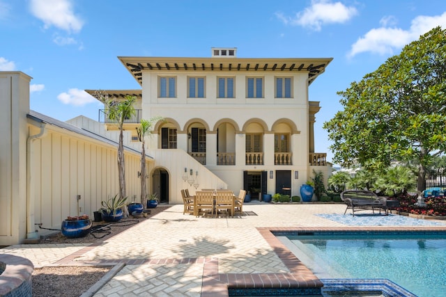 back of property featuring a balcony and a patio