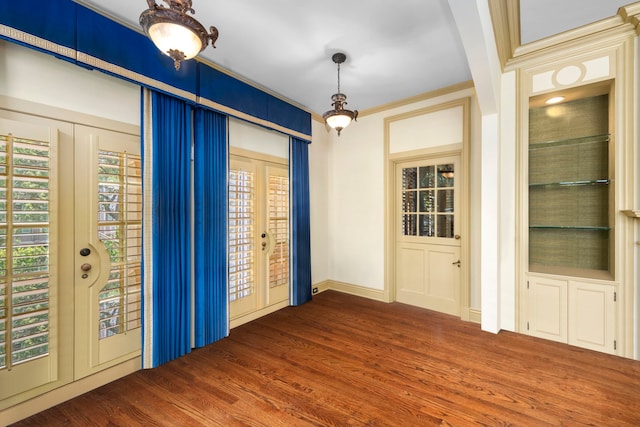 unfurnished room with crown molding, hardwood / wood-style flooring, and french doors