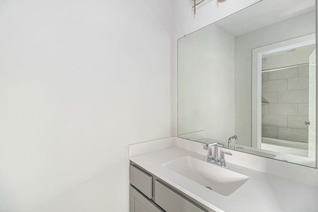 bathroom featuring a tile shower and vanity