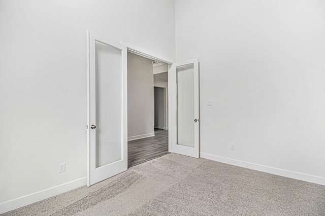 spare room featuring carpet floors and a towering ceiling