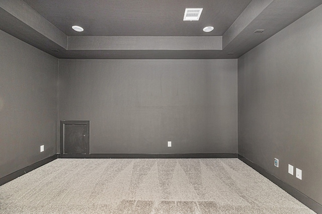 carpeted empty room featuring a tray ceiling