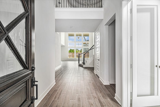 corridor with hardwood / wood-style flooring and a high ceiling