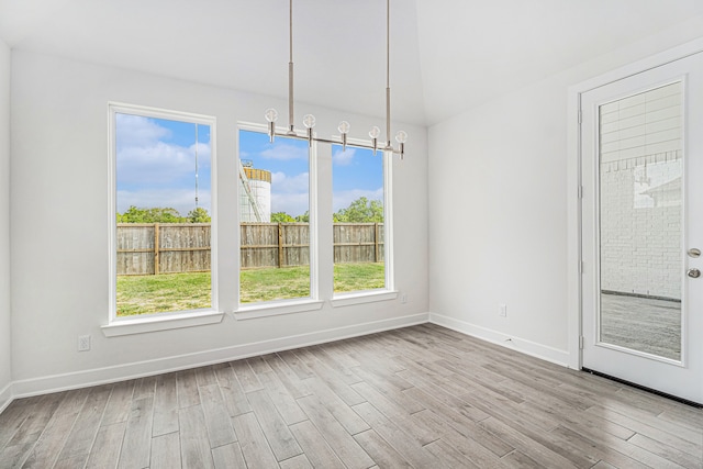 unfurnished room featuring light wood-type flooring and a chandelier